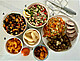 Figure from the original publication: One-days’ worth of food consumed by a participant assigned to the 2000 kcal increment based on calculated caloric requirements. Photo depicts menu items from day 4 of the 4-day rotating menu of the restore diet (approximately 46 g dietary fiber): (A) sweet potato and black bean hash and (B) mandarin oranges (breakfast); (C) quinoa tabbouleh salad and (D) canned pears (lunch); (E) baked pork tenderloin, roasted Jerusalem artichokes and potatoes, and coleslaw (dinner); and (F) dried apricots and almonds (snack).  Photo by: A.M.A.